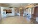 Open concept living room with tile floors, decorative pillars, kitchen access, and bright natural light at 3580 Prairie Ave, Pahrump, NV 89048