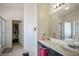 Bright bathroom featuring double sinks, large mirror, walk in closet, and a walk-in shower at 4529 Gracemont Ave, Las Vegas, NV 89139