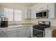 This kitchen features stainless steel appliances, gray cabinets, and a window providing natural light at 4529 Gracemont Ave, Las Vegas, NV 89139
