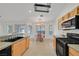 Modern kitchen with oak cabinets, tile floors, granite countertops, and black appliances at 4624 Windy Hollow St, Las Vegas, NV 89130