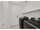 Convenient laundry room features modern, dark appliances and ample storage space on shelving at 4624 Windy Hollow St, Las Vegas, NV 89130