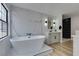 Contemporary bathroom featuring a freestanding tub, marble accent wall, and modern fixtures at 5151 Tennis Ct, Las Vegas, NV 89120