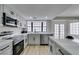 Modern kitchen featuring stainless steel appliances, grey cabinets, and a bright window at 5151 Tennis Ct, Las Vegas, NV 89120