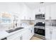 Bright kitchen features white cabinets, quartz countertops, stainless steel appliances, and stylish tile backsplash at 5264 Silverheart Ave, Las Vegas, NV 89142