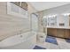 Luxurious bathroom with a soaking tub, glass-enclosed shower, and modern fixtures at 5801 Exbury Gardens Ct, Las Vegas, NV 89118