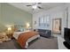 Cozy bedroom features a comfortable bed, a sitting area, and a large window with plantation shutters at 5801 Exbury Gardens Ct, Las Vegas, NV 89118