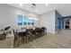 Modern dining room with a large table, chairs, plantation shutters, and wood-look tile flooring at 5801 Exbury Gardens Ct, Las Vegas, NV 89118