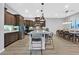 Kitchen featuring a large island, stainless steel appliances, dark wood cabinetry, and adjacent dining area at 5801 Exbury Gardens Ct, Las Vegas, NV 89118