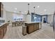 Open-concept kitchen with granite island, stainless steel appliances, and a dining area with modern lighting at 5801 Exbury Gardens Ct, Las Vegas, NV 89118