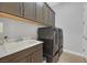 Laundry room with cabinetry above the front load washer and dryer at 5801 Exbury Gardens Ct, Las Vegas, NV 89118