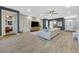 Spacious living room with hardwood floors and a stone accent wall with a large TV at 5801 Exbury Gardens Ct, Las Vegas, NV 89118