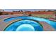 A custom pool includes an in-ground spa with stacked stone trim and waterfall at 5801 Exbury Gardens Ct, Las Vegas, NV 89118