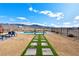 Beautiful backyard featuring a modern pool, a stone walkway, manicured landscaping, and mountain views at 6101 Cavalry Trl, Pahrump, NV 89060