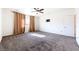 Large carpeted bedroom with a ceiling fan and neutral color scheme at 6101 Cavalry Trl, Pahrump, NV 89060