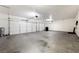 View of the oversized three car garage featuring bright lighting, concrete flooring and three separate doors at 6101 Cavalry Trl, Pahrump, NV 89060