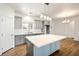 Bright kitchen showcases gray cabinets, stainless steel appliances, a large island, and hardwood floors at 6101 Cavalry Trl, Pahrump, NV 89060