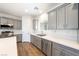 Modern kitchen with gray cabinets, stainless steel appliances, quartz countertops, and stylish hardwood flooring at 6101 Cavalry Trl, Pahrump, NV 89060