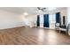 Large living area with wood flooring, a ceiling fan and a bright window at 6101 Cavalry Trl, Pahrump, NV 89060