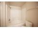 Bathroom showcasing the tub and shower with white tiling, along with the toilet at 7155 S Durango Dr # 205, Las Vegas, NV 89113