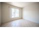 Simple bedroom with a large window providing natural light and tile flooring at 7155 S Durango Dr # 205, Las Vegas, NV 89113