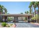 Community entrance with covered gate and lush palm trees lining the entrance at 7155 S Durango Dr # 205, Las Vegas, NV 89113