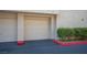 Two-car garage with neutral color, complemented by manicured greenery at 7155 S Durango Dr # 205, Las Vegas, NV 89113
