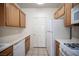 Functional kitchen with essential appliances, wood cabinets, and neutral countertops at 7155 S Durango Dr # 205, Las Vegas, NV 89113