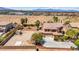 Wide aerial shot of a property with ample space, featuring a house, pool, and large expanse of desert landscaping at 7794 River Mist Ct, Las Vegas, NV 89113