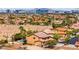Scenic aerial view of a neighborhood with a distant skyline, showcasing a community with a mix of desert and lush landscapes at 7794 River Mist Ct, Las Vegas, NV 89113
