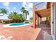 Multi-story home with covered patio, BBQ, balconies, and in-ground pool with tropical plants at 7794 River Mist Ct, Las Vegas, NV 89113