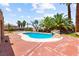 Manicured backyard featuring an in-ground pool, tropical landscaping, and desert views at 7794 River Mist Ct, Las Vegas, NV 89113