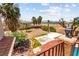 Backyard features desert landscaping with green grass accents, trees, concrete pads and fencing at 7794 River Mist Ct, Las Vegas, NV 89113