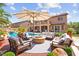 Beautiful backyard featuring a pool, a fire pit, ample seating, and an outdoor kitchen at 7794 River Mist Ct, Las Vegas, NV 89113