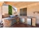 Built-in outdoor kitchen with BBQ grill, cooktop, bar seating, and stainless steel appliances at 7794 River Mist Ct, Las Vegas, NV 89113