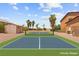Private pickleball court surrounded by lush landscaping and a sunny blue sky at 7794 River Mist Ct, Las Vegas, NV 89113