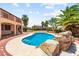 Backyard in-ground pool features rock waterfall, tropical landscaping, and a jacuzzi at 7794 River Mist Ct, Las Vegas, NV 89113