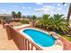 An in-ground kidney-shaped pool features rock waterfall features and lush palm trees at 7794 River Mist Ct, Las Vegas, NV 89113