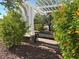 Shady arbor bench with flowering bushes providing a relaxing spot in the community at 7814 Granite City Ct, Las Vegas, NV 89166