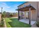 Home features a covered patio, sliding glass doors, grill, and artificial turf at 7814 Granite City Ct, Las Vegas, NV 89166