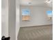Bedroom with neutral carpet and white walls, featuring two windows at 7814 Granite City Ct, Las Vegas, NV 89166