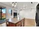 The kitchen island overlooks a large living space and backyard through sliding glass doors at 7814 Granite City Ct, Las Vegas, NV 89166