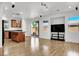 Open-concept living room with wood floors, kitchen island, sliding glass doors, and a modern entertainment center at 7814 Granite City Ct, Las Vegas, NV 89166