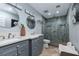 Modern bathroom featuring dual sinks, granite countertops, and a glass-enclosed shower with decorative tile at 800 Antonio Dr, Las Vegas, NV 89107