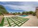 Inviting backyard with a sparkling pool, lush landscaping, and a cozy fire pit area at 8032 Audubon Canyon St, Las Vegas, NV 89131