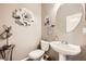 Powder room with pedestal sink, decorative mirror and accents, and toilet at 8032 Audubon Canyon St, Las Vegas, NV 89131