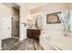 Bathroom featuring soaking tub and shower with brown vanity and stylish tile flooring at 8032 Audubon Canyon St, Las Vegas, NV 89131