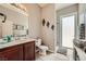 Bathroom with wood cabinets, sink, toilet, and a walk-in shower at 8032 Audubon Canyon St, Las Vegas, NV 89131