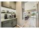 Coffee bar with marble countertop, gray cabinetry, and a view towards the kitchen island and pool at 8032 Audubon Canyon St, Las Vegas, NV 89131