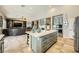 Open-concept kitchen with island seating flows into a comfortable living area with entertainment center at 8032 Audubon Canyon St, Las Vegas, NV 89131