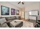 Cozy living room featuring a gray sectional, ottoman, and movie posters at 8032 Audubon Canyon St, Las Vegas, NV 89131